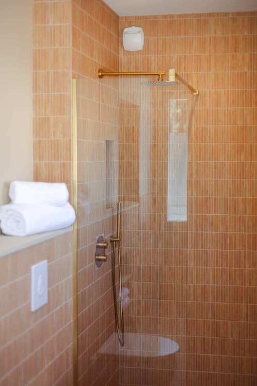 Salle de bains moderne avec mitigeur bronze et paroi vitrée de la Chambre Marlène à l'hôtel boutique L'Ode à Pierre, Dax
