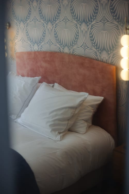 Chambre cosy à L'Ode à Pierre, Dax avec tête de lit rose, draps blancs et papier peint à motifs
