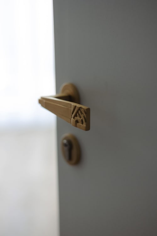 Poignée de porte en bronze et serrure sur porte grise à l'Ode à Pierre, hôtel de Dax