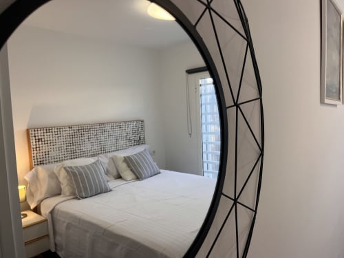 Dormitorio moderno en FTV Holidays Homes, La Oliva, con cama blanca, cabecero geométrico y arco decorativo de metal negro