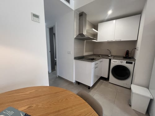 Cocina y comedor modernos en alquiler vacacional La Oliva con electrodomésticos y mesa de madera