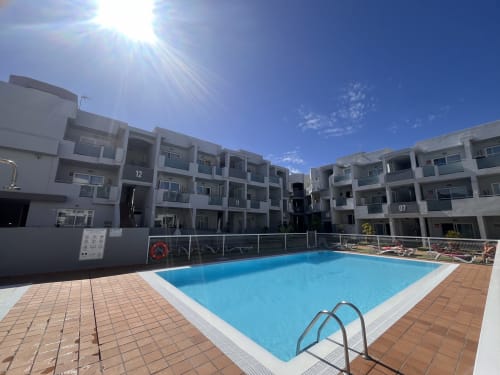 Complejo residencial moderno con piscina azul y terraza en La Oliva, Fuerteventura