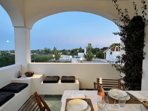 Sala da pranzo della villa Ostuni Bloom con colonnato bianco ad arco che affaccia sulla piscina al tramonto, Pietra & Luce, Ostuni Italia