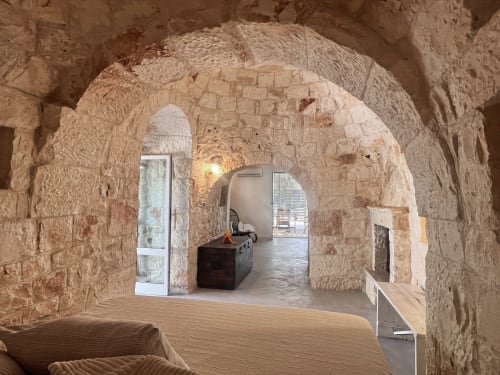 Archi in pietra storici nella villa di Ostuni con arredi moderni e vista accesso piscina
