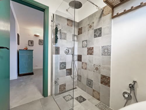 Moderna doccia aperta con piastrelle a motivi geometrici nella villa Pietra & Luce a Ostuni, Italia