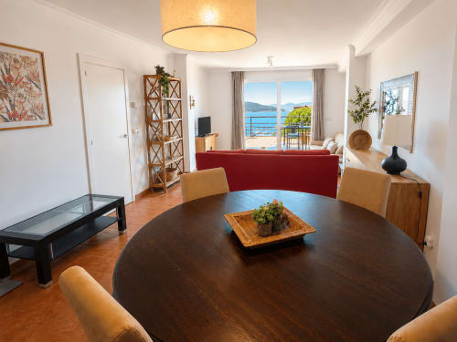 Amplio comedor del hotel Holibai en Baiona con mesa redonda, vistas al océano y equipamientos modernos