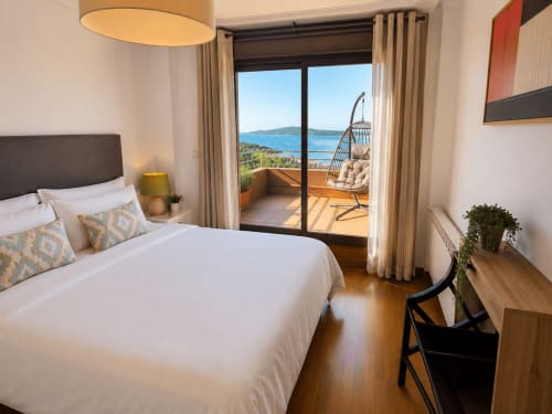 Habitación moderna del hotel Holibai en Baiona con vistas al mar, cama king y balcón privado con silla colgante