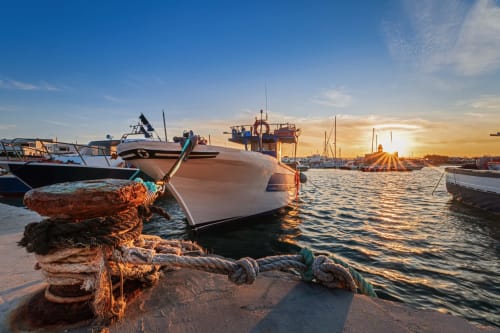 Vista del porto al tramonto con barche da pesca ormeggiate a Ostuni, Italia vicino a Pietra & Luce