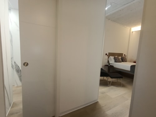 Dormitorio moderno en apartamento El Rincón de Sevilla, San Juan de Aznalfarache, con cama matrimonial y paredes blancas minimalistas.
