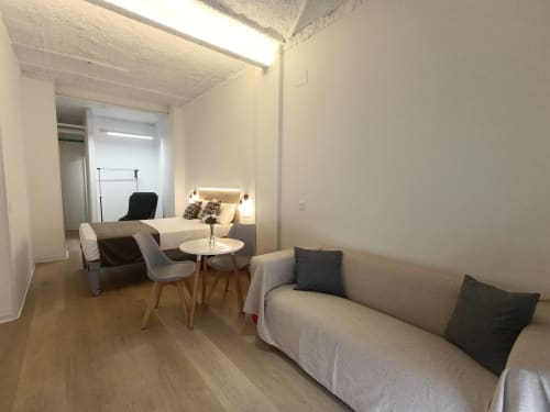 Moderno estudio en El Rincón de Sevilla con sofá, cama, zona de comedor y pisos de madera