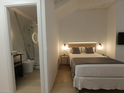 Dormitorio moderno en apartamento El Rincón de Sevilla, Sevilla, con baño privado, cama queen y iluminación ambiental