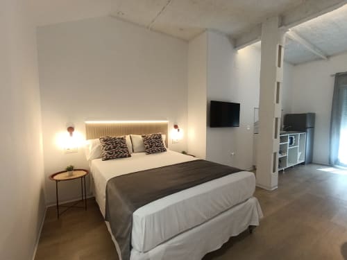 Dormitorio moderno en el apartamento El Rincón de Sevilla con cama de matrimonio, iluminación LED en cabecero y TV de pantalla plana