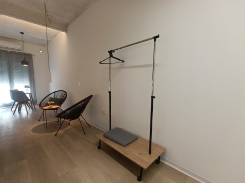 Interior minimalista de apartamento moderno en El Rincón de Sevilla con sillas negras, banco de madera y perchero