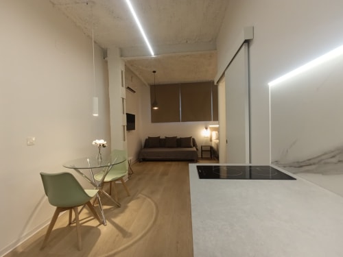 Cocina y sala moderna en El Rincón de Sevilla con mesa de comedor, sofá y diseño contemporáneo en San Juan