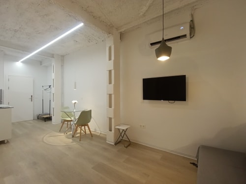 Apartamento estudio moderno en San Juan de Aznalfarache con comedor, TV empotrada, iluminación colgante y diseño minimalista