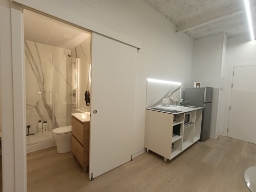Pequeña cocina y baño modernos en El Rincón de Sevilla con muebles blancos y electrodomésticos acero inoxidable