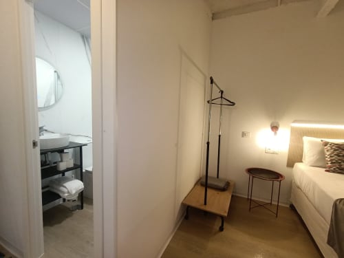 Dormitorio moderno en apartamento El Rincón de Sevilla con cama, baño, perchero y decoración minimalista