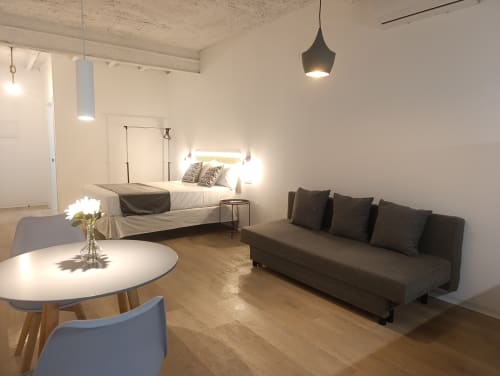 Moderno estudio en El Rincón de Sevilla con sofá cama, mesa de comedor y dormitorio con sábanas blancas en San Juan de