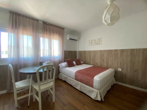 Dormitorio moderno en apartamento El Rincón II de la Macarena, Sevilla con cama, escritorio y vistas a la ciudad