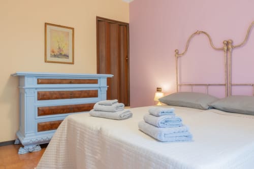 Camera del Prince Garda hotel a Salò con cassettone blu, letto in ferro e asciugamani freschi sulla biancheria bianca