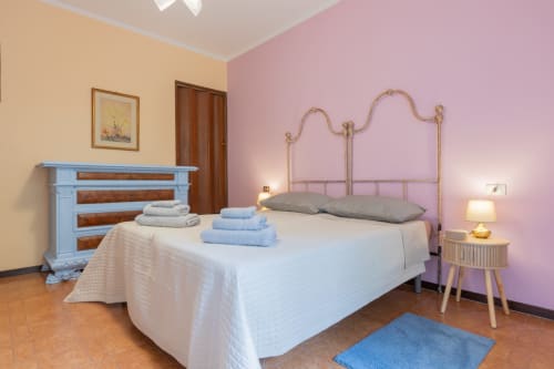 Elegante camera da letto al Prince Garda hotel di Salò con pareti rosa, letto in ottone e accenti blu