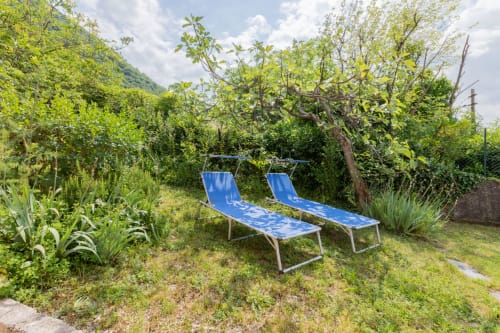 Due sdraio blu in un rigoglioso giardino dell'hotel Prince Garda, Salò, Italia