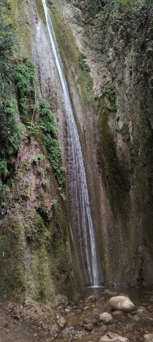 Cascata che scende da scogliere rocciose ricoperte di muschio in una pozza, presso l'hotel Prince Garda a Salò