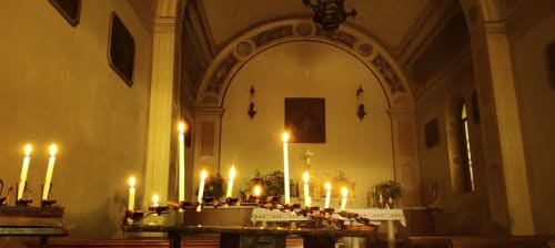 Altare illuminato da candele con soffitto ad arco nella cappella dell'Hotel Prince Garda a Salò, Italia