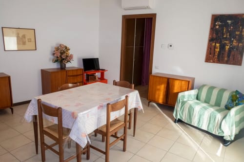 Esperanto apartment living area at Casa di Cinti, Pianoro, with dining table, sofa, and wooden furnishings.