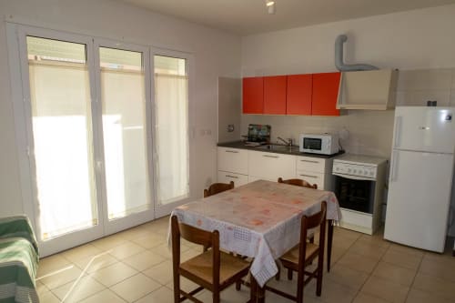 Esperanto apartment kitchen and dining area at Casa di Cinti B&B in Pianoro, with red cabinets and dining table