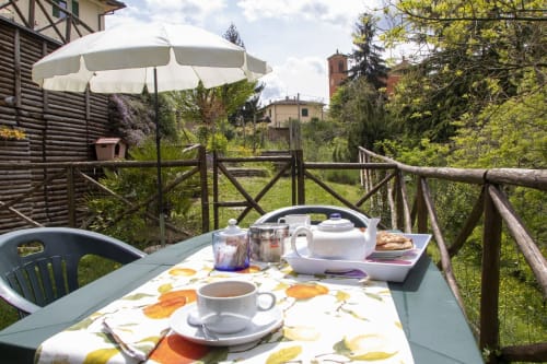 Terrazza colazione toscana a Casa di Cinti con servizio di tè, pasticceria e vista sulla campagna