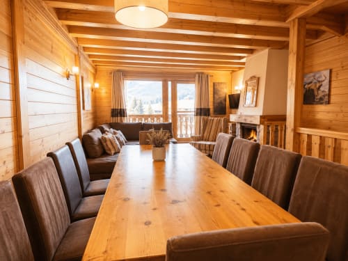Salle à manger élégante du Chalet du Vallon aux Étoiles de la Plagne avec table en bois, cheminée et vue montagne
