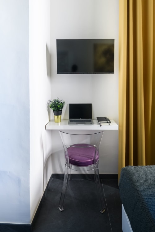 Moderno spazio di lavoro nell'Almatros Yellow Apartment a Sulmona, con TV a parete, scrivania con laptop e sedia trasparente
