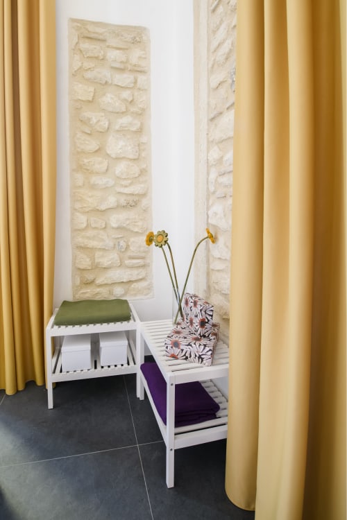 Appartamento Giallo dell'hotel Almatros a Sulmona con muri in pietra, mensole bianche e tende dorate