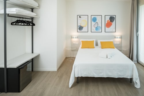 Camera moderna di Villa Mary con letto queen, cuscini gialli, arte astratta a parete, scrivania e armadio a Santa
