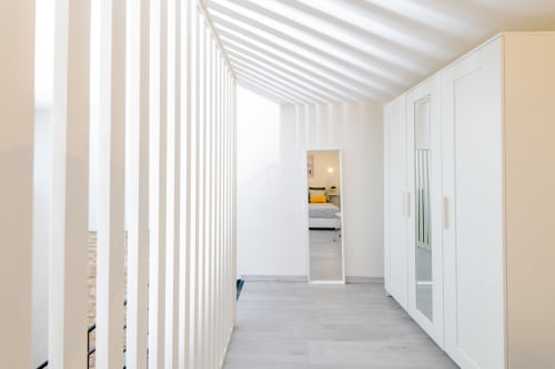 Corridoio luminoso dell'Almatros Green Apartment a Sulmona con soffitto a strisce bianche, guardaroba moderno e vista sulla camera