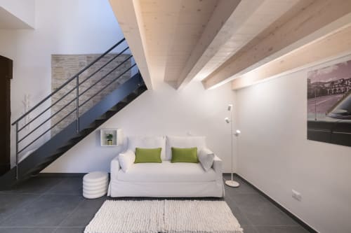 Soggiorno Green Apartment all'hotel Almatros di Sulmona, con divano bianco, scala moderna e travi a vista