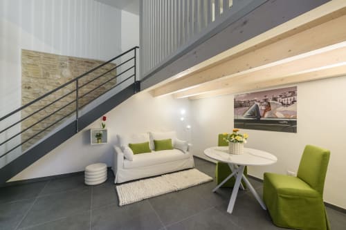 Green Apartment dell'hotel Almatros di Sulmona con moderno salotto, divano color crema e sedie verde lime