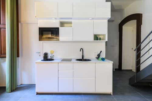 Moderna cucina bianca nella Green Apartment dell'Almatros Hotel a Sulmona, con elettrodomestici integrati e design contemporaneo