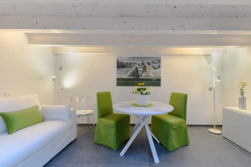Appartamento Green dell'hotel Almatros a Sulmona con moderna zona living, tavolo rotondo bianco e sedie verdi