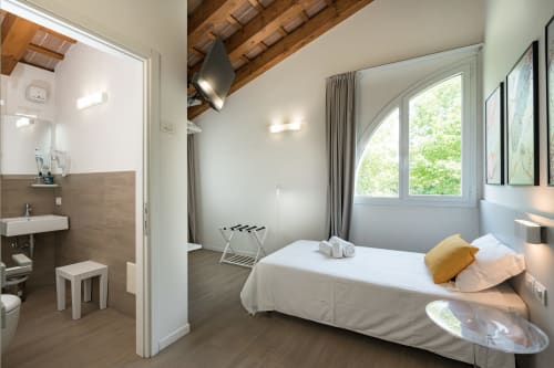 Camera moderna all'Hotel Villa Mary con vista giardino, bagno privato, travi in legno e arredi contemporanei