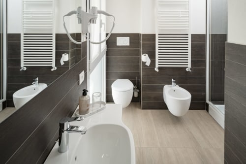 Bagno moderno dell'Hotel Villa Mary con doppio lavabo, toilet, bidet, scaldasalviette elettrici e pavimentazione effetto legno a Santa