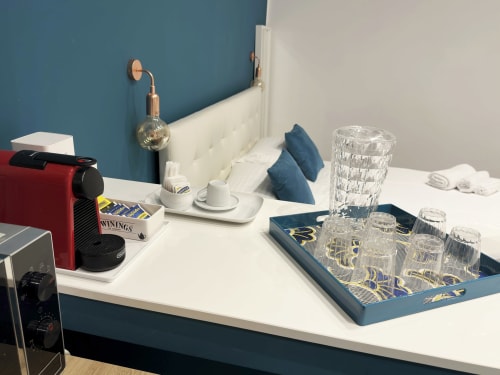 Moderno desk della camera d'hotel presso l'Harmony House Bari con macchina da caffè, bicchieri e vassoio
