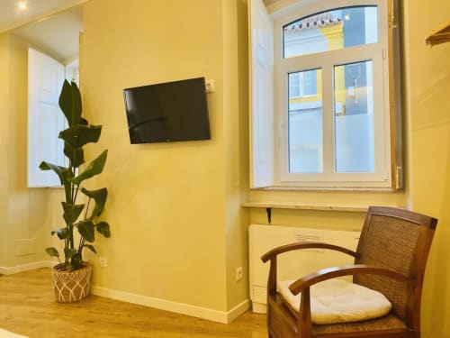Quarto amarelo-brilhante na Santa Cruz Historic Guest House em Lagos com TV tela plana, cadeira de madeira, planta em vaso e grande