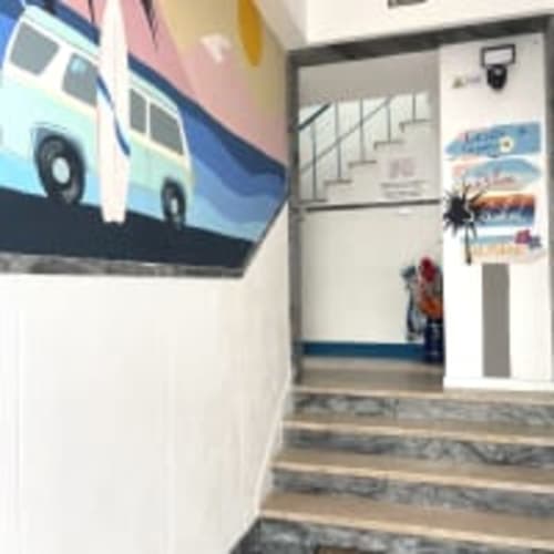Vila Alexandra hostel studio entrance in Costa da Caparica with staircase and colorful wall murals