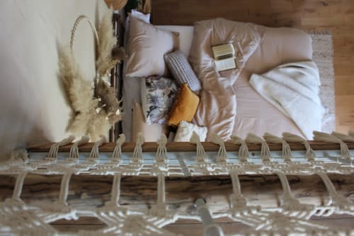 Overhead view of cozy bedroom at Le Petit Bégou with beige bedding, pampas grass decor, and mountain views in