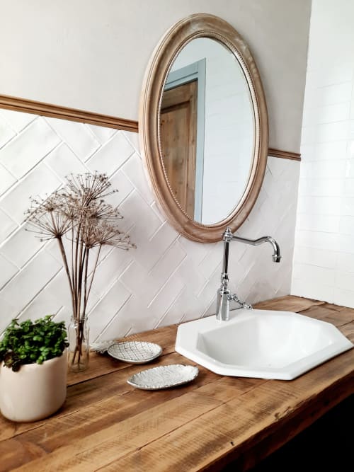 Elegant bathroom vanity at Le Petit Bégou with oval mirror, white square sink, wooden counter, and dried flowers in