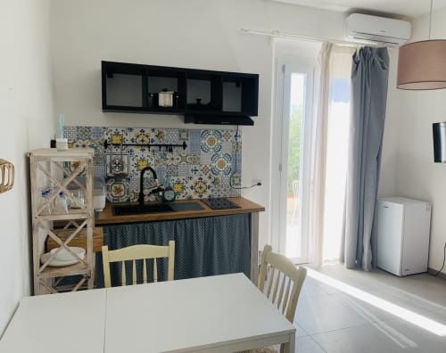 Moderna cucina con piastrelle colorate, zona pranzo e vista sul giardino presso Ca' Salino BnB in Italia