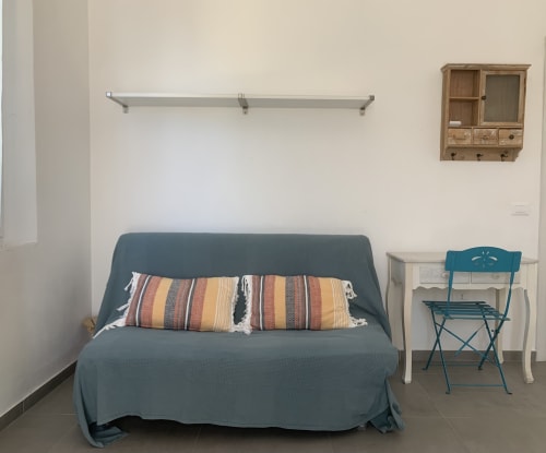Camera accogliente di Ca' Salino B&B con divano letto blu, cuscini rigati e vista sul giardino a Villa Inferno, Italia