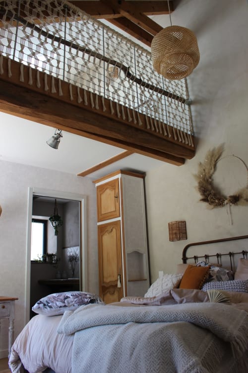 Cozy bedroom at Le Petit Bégou with wooden beams, mezzanine loft, and garden view in Saint-Auban-dʼOze